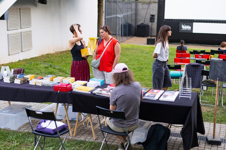 obiskovalci pred stojnico s knjigami