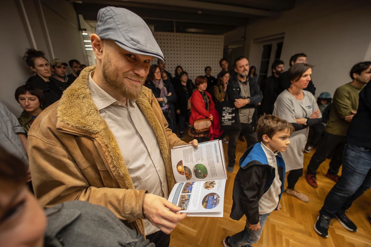 obiskovelec gleda knjižico o razstavi za otroke