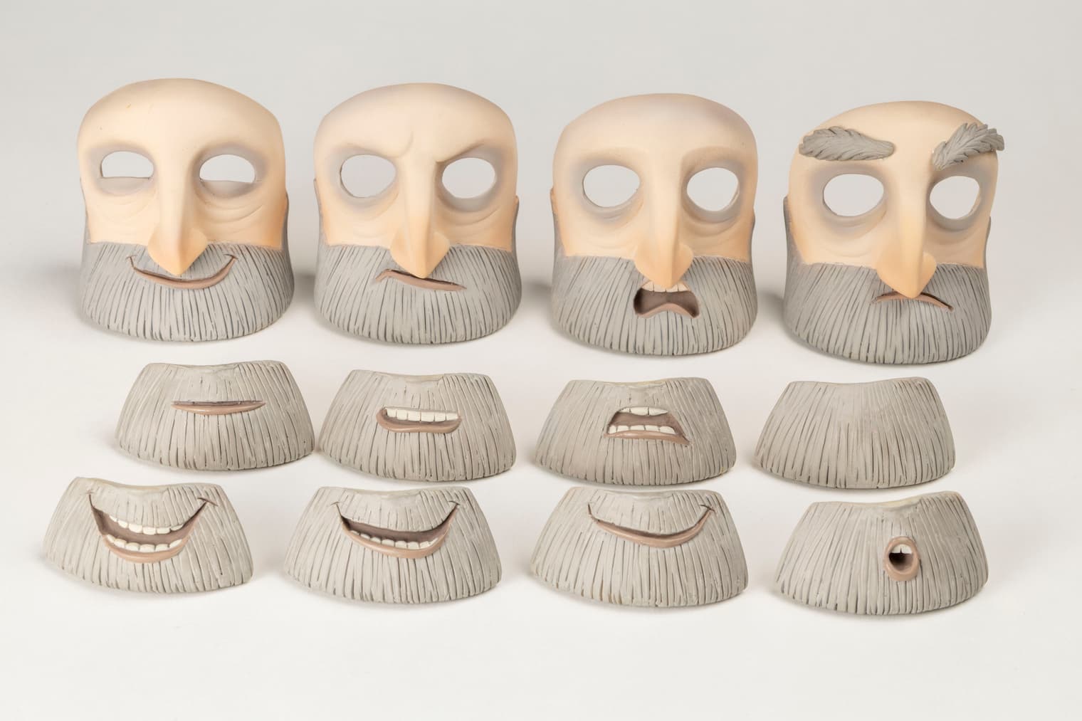 obrazne maske. V zgornji vrstici so različne sestavljene variante zgornjega dela obraza z očmi in nosom ter različno oblikovanih ust, v spodnjih dveh vrsticah pa so samo različni primeri ustnega dela obraza.